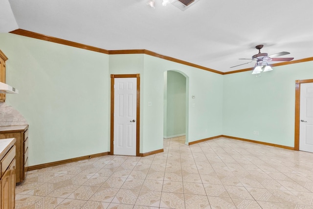 908 E Belknap St, Ennis, TX 75119 - spare room featuring arched walkways, ornamental molding, ceiling fan, and baseboards