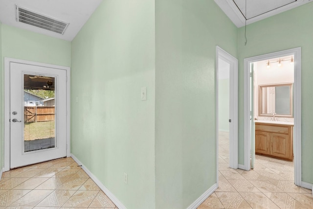 908 E Belknap St, Ennis, TX 75119 - hallway featuring light tile patterned flooring, attic access, baseboards, and a sink