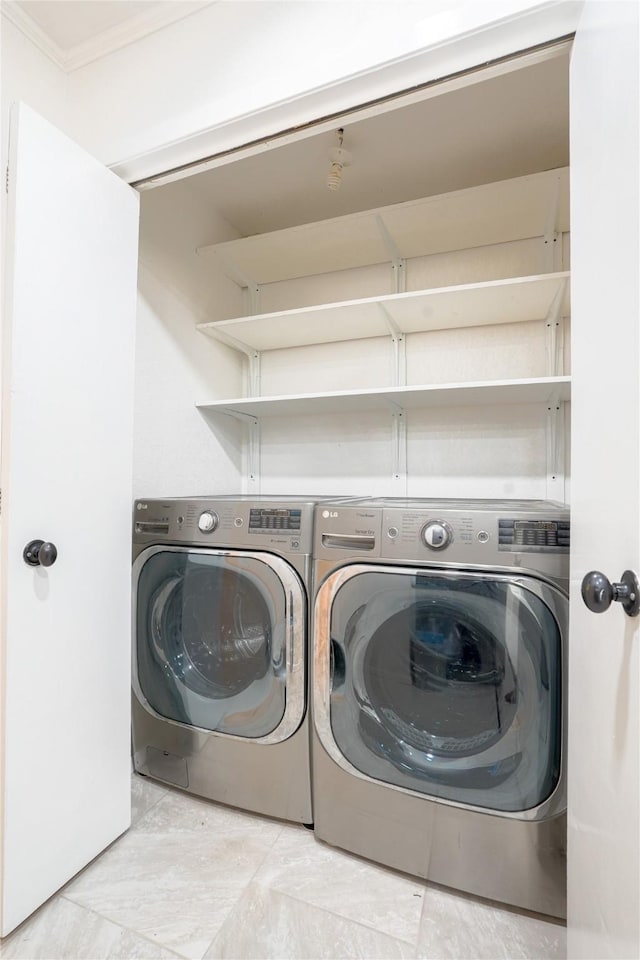 washroom featuring washing machine and clothes dryer, laundry area, and ornamental molding