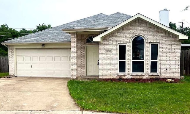 ranch-style house featuring a chimney, driveway, brick siding, and a garage