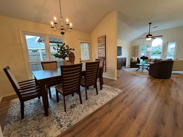 dining area featuring baseboards, vaulted ceiling, a healthy amount of sunlight, and wood finished floors