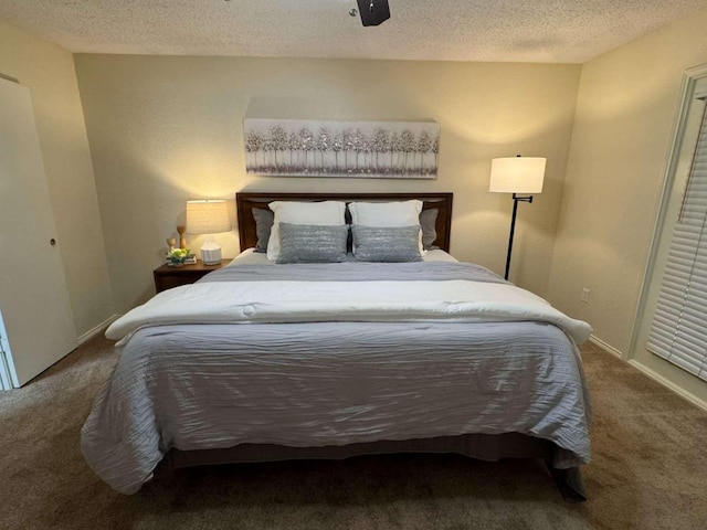 carpeted bedroom with baseboards and a textured ceiling