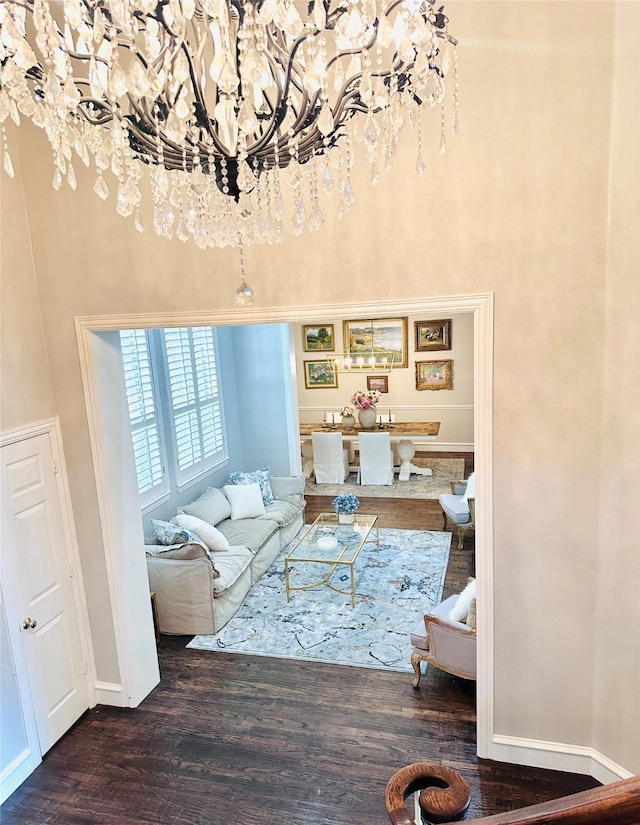 8004 Ashby Ct, Plano, TX 75025 - living area featuring a chandelier, wood finished floors, a towering ceiling, and baseboards