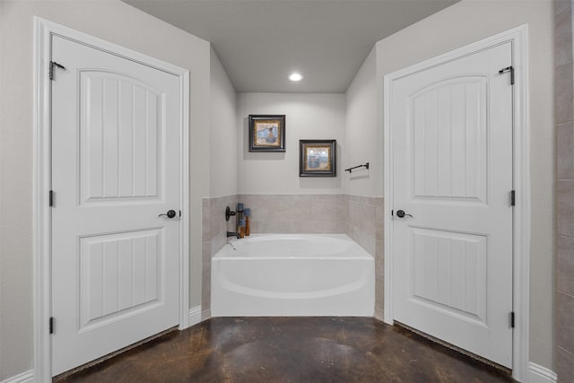 full bathroom featuring finished concrete flooring, a garden tub, and recessed lighting