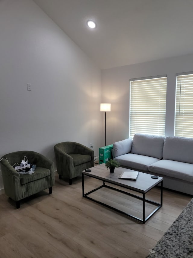 living room featuring light wood-style flooring, recessed lighting, and vaulted ceiling