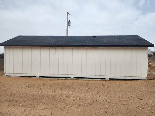 view of side of home with a shingled roof