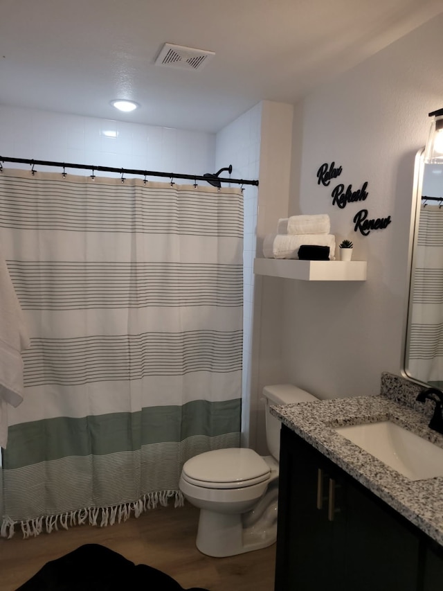 bathroom with toilet, wood finished floors, vanity, visible vents, and a shower with shower curtain