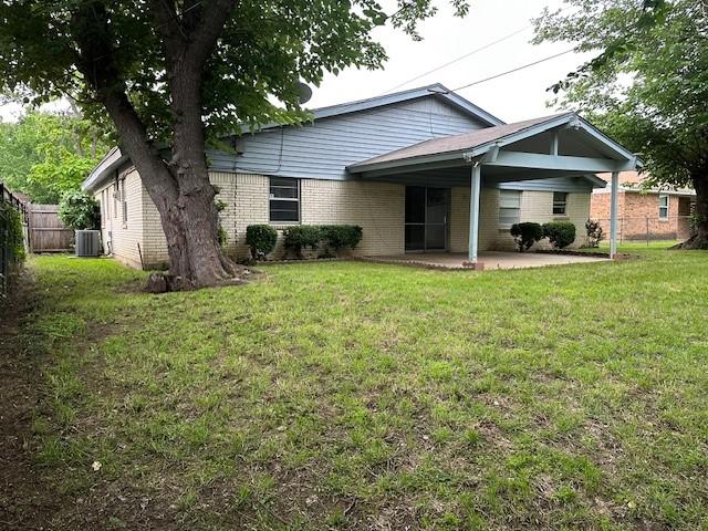 back of house featuring a yard, brick siding, fence, cooling unit, and a patio