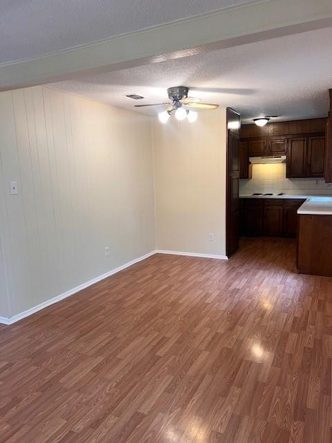 unfurnished living room featuring baseboards, wood finished floors, and a ceiling fan