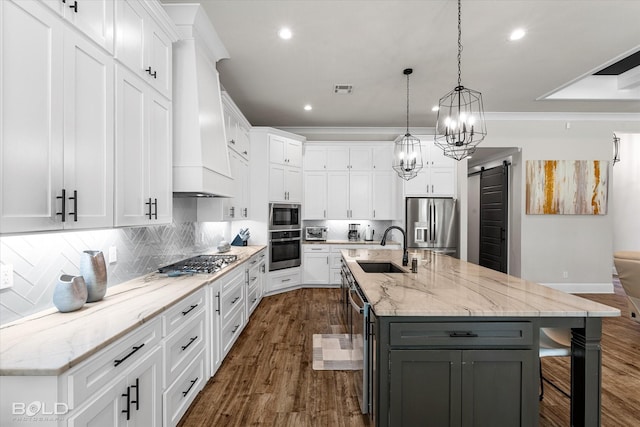 kitchen with a sink, gray cabinets, a barn door, appliances with stainless steel finishes, and recessed lighting