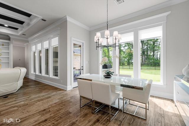 dining room with wood finished floors, visible vents, baseboards, a chandelier, and ornamental molding