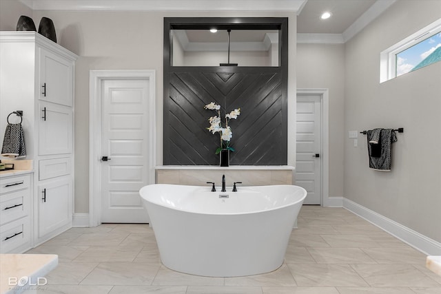 bathroom with recessed lighting, baseboards, marble finish floor, ornamental molding, and a soaking tub