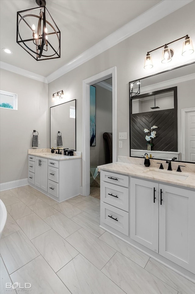 full bath with a sink, two vanities, a notable chandelier, crown molding, and marble finish floor