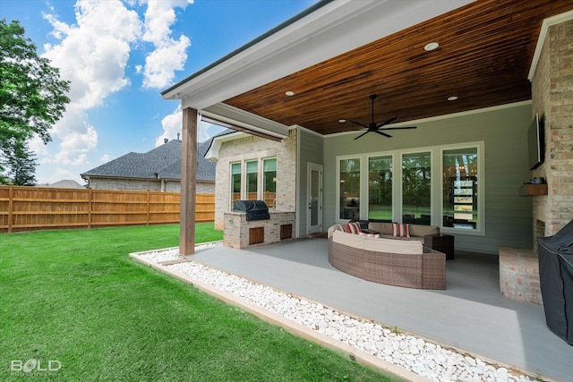 view of patio / terrace featuring exterior kitchen, outdoor lounge area, a grill, ceiling fan, and a fenced backyard