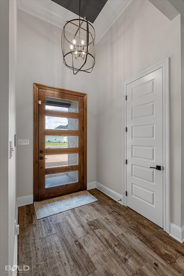 foyer with baseboards, a notable chandelier, and wood finished floors