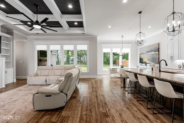 living area featuring crown molding, dark wood finished floors, and recessed lighting