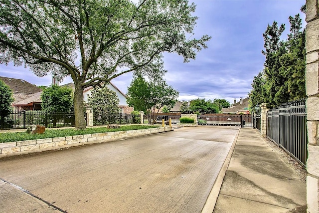 10853 Dixon Branch Dr, Dallas, TX 75218 - view of concrete street with a gated entry and curbs
