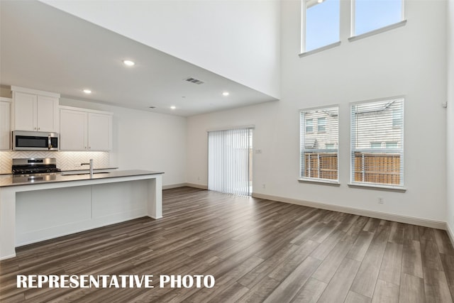 1359 Whipsaw Trl, Celina, TX 75009 - kitchen featuring visible vents, dark wood finished floors, decorative backsplash, open floor plan, and appliances with stainless steel finishes