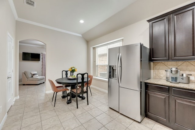 4416 Coney Island Dr, Frisco, TX 75036 - kitchen with dark brown cabinetry, arched walkways, stainless steel refrigerator with ice dispenser, and visible vents