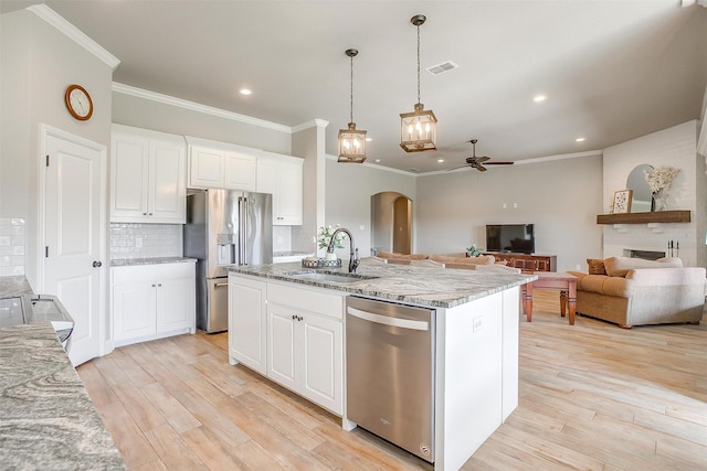 kitchen with a sink, stainless steel appliances, visible vents, crown molding, and a ceiling fan