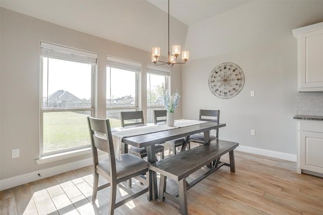 dining space with light wood-type flooring, a chandelier, and baseboards