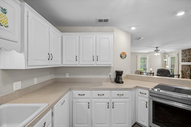 kitchen featuring white cabinetry, visible vents, stainless steel electric stove, and a sink