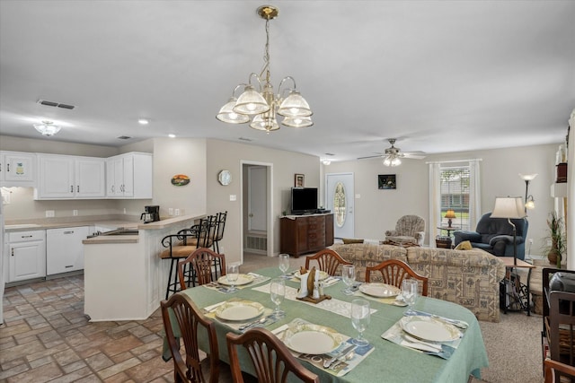 dining area featuring visible vents, brick floor, ceiling fan with notable chandelier, and recessed lighting