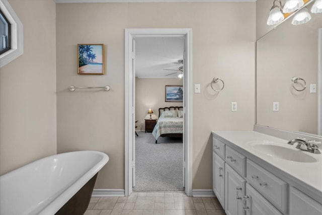 full bath featuring vanity, ensuite bath, a ceiling fan, a freestanding bath, and baseboards