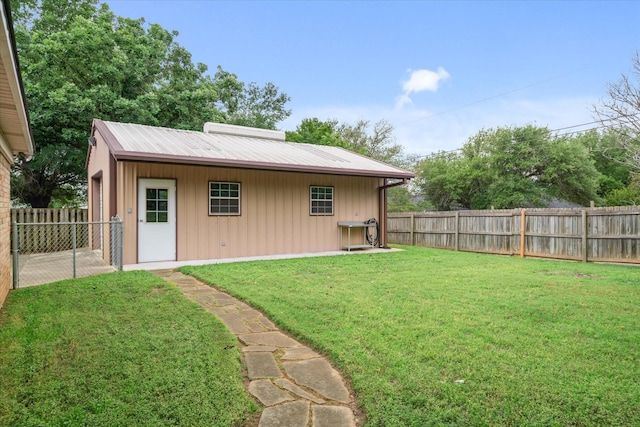 rear view of house with a yard, board and batten siding, and a fenced backyard