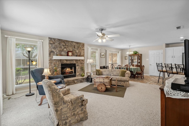 carpeted living area featuring visible vents, a fireplace, baseboards, and ceiling fan