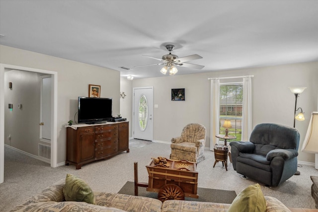 living area with light carpet, baseboards, a ceiling fan, and visible vents