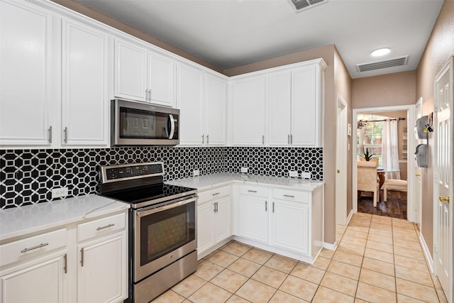 4849 Crumbcake Dr, Fort Worth, TX 76244 - kitchen featuring stainless steel appliances, light tile patterned floors, light countertops, tasteful backsplash, and white cabinetry