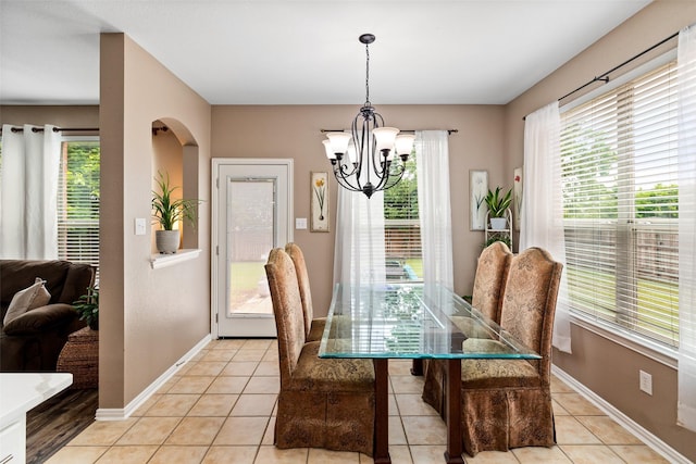 dining space featuring healthy amount of natural light, a chandelier, and baseboards