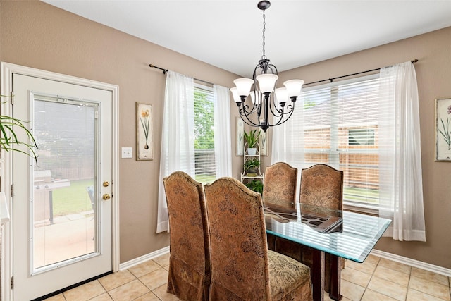 dining space with a chandelier, light tile patterned floors, and baseboards