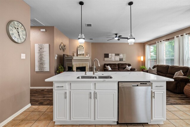 kitchen with dishwasher, a sink, open floor plan, and light tile patterned flooring