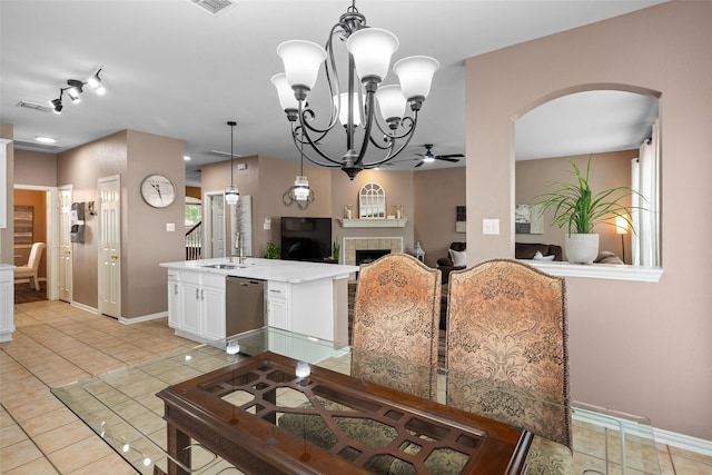 dining space featuring arched walkways, light tile patterned flooring, a chandelier, baseboards, and a tile fireplace