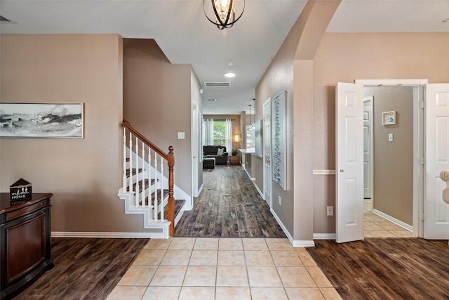 foyer entrance featuring wood finished floors, stairway, and baseboards