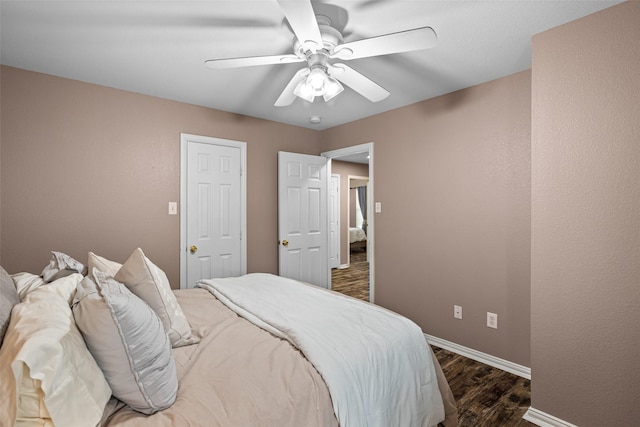 bedroom featuring dark wood-type flooring, baseboards, and a ceiling fan