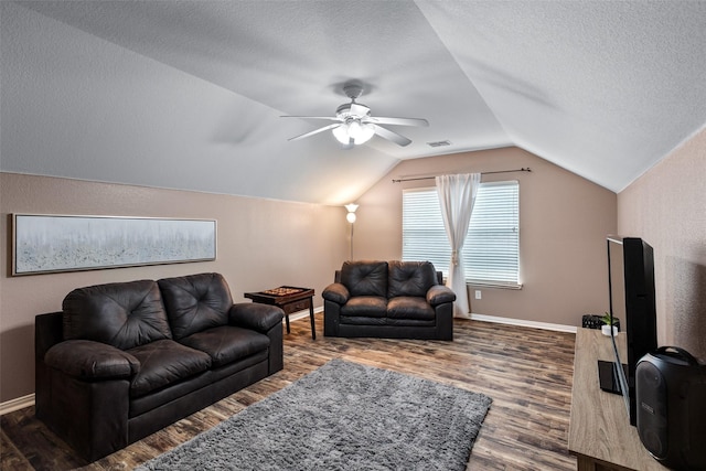 living area with dark wood-style flooring, vaulted ceiling, a ceiling fan, baseboards, and a textured ceiling