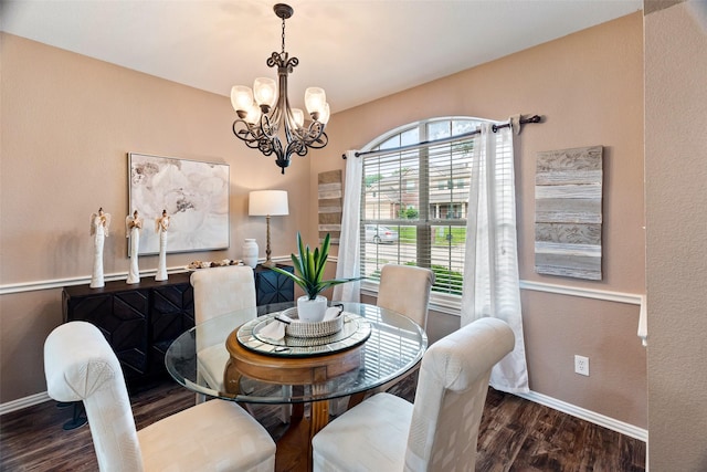 dining area featuring baseboards, wood finished floors, and a chandelier