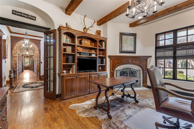 1719 Byron Nelson Pkwy, Colleyville, TX 76092 - office area featuring light wood-style flooring, a fireplace, beamed ceiling, arched walkways, and a chandelier