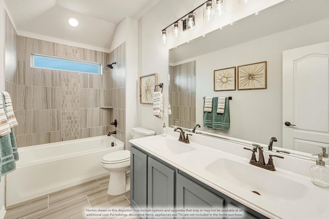 bathroom with a sink, double vanity, toilet, and tub / shower combination