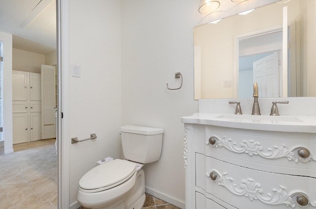 bathroom with vanity, toilet, baseboards, and tile patterned floors