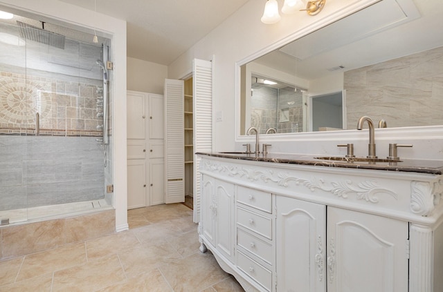 full bathroom featuring a shower stall, a closet, double vanity, and a sink