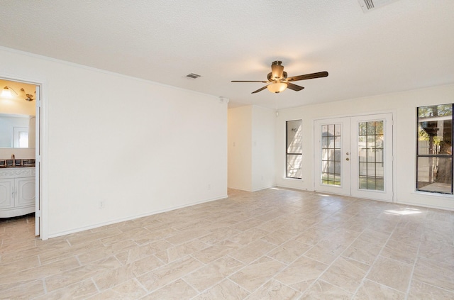 unfurnished room featuring visible vents, french doors, ceiling fan, and a sink