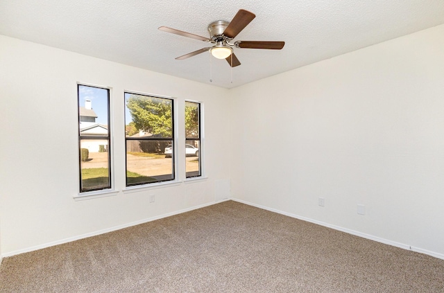 carpeted spare room with baseboards and ceiling fan