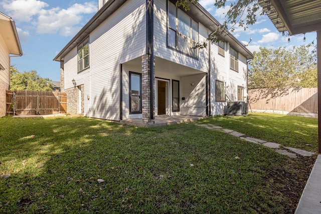 back of house featuring a yard, fence, central AC unit, and a patio