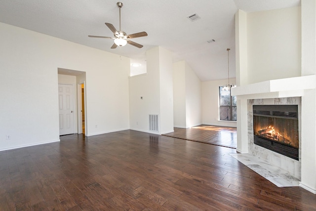 unfurnished living room with dark wood finished floors, visible vents, a fireplace, and a ceiling fan
