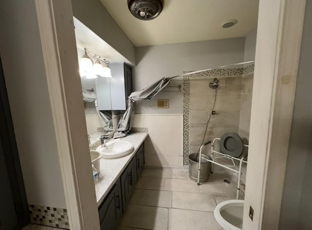 524 Terrace Dr, Desoto, TX 75115 - bathroom featuring a tile shower, tile patterned flooring, vanity, and a wainscoted wall