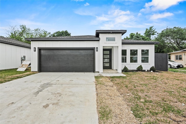 7819 Brownsville Ave, Dallas, TX 75216 - prairie-style home featuring a garage, a front lawn, board and batten siding, a shingled roof, and driveway